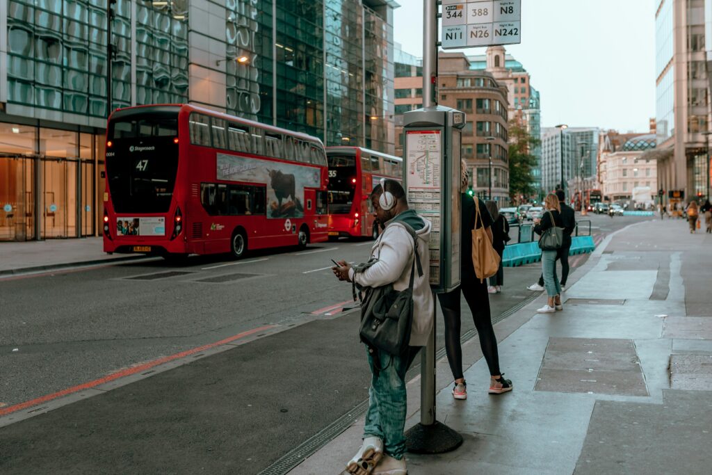 Man Wearing Headphones Leaning on a Post