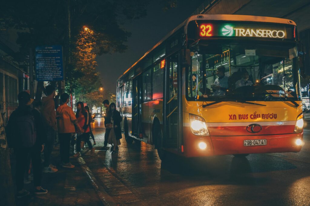 Evening scene of commuters boarding a bus in Hanoi, Vietnam.